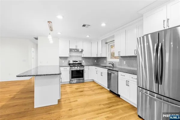 a kitchen with stainless steel appliances granite countertop a refrigerator sink and cabinets