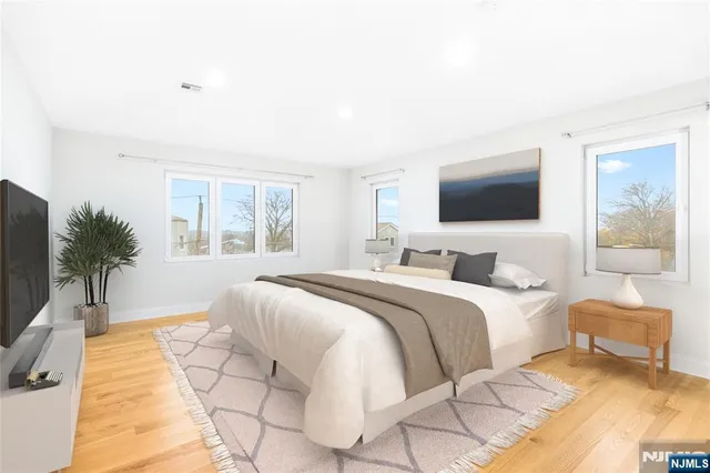 a bedroom with a bed and a flat screen tv