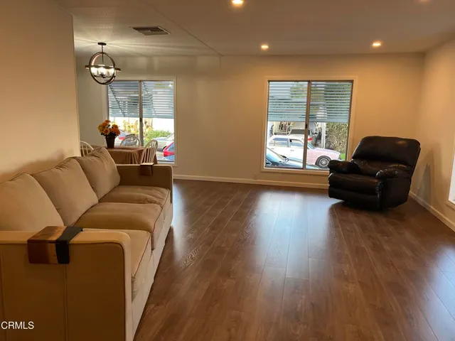 a living room with furniture and a wooden floor