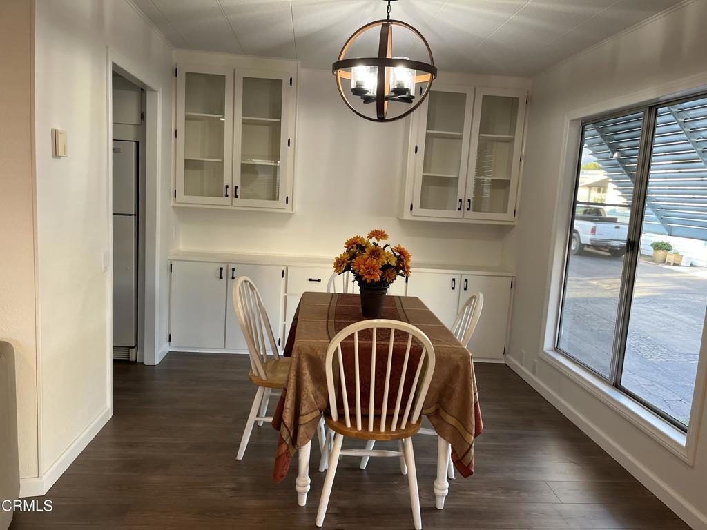 103 Gay Drive, Unit 103 Ventura, CA 93003 - Photo 4 of 17 a view of a dining room with furniture wooden floor and chandelier