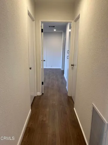 a view of a hallway with wooden floor