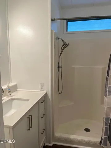 a bathroom with a sink a mirror and a shower