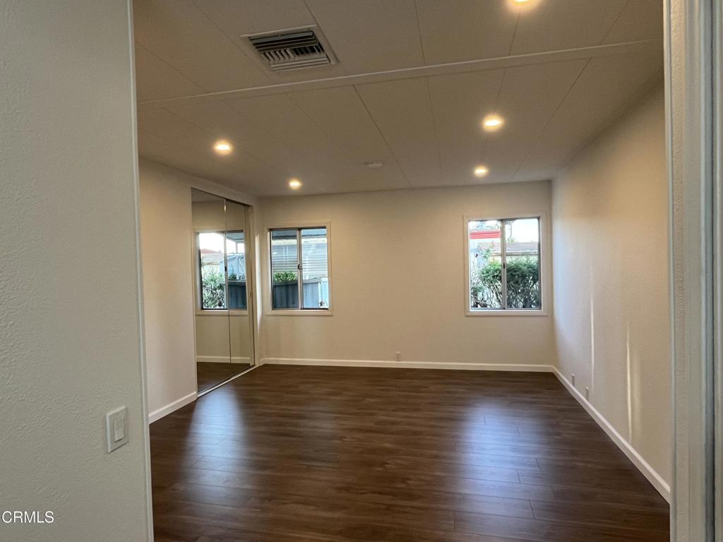 103 Gay Drive, Unit 103 Ventura, CA 93003 - Photo 9 of 17 an empty room with wooden floor and windows