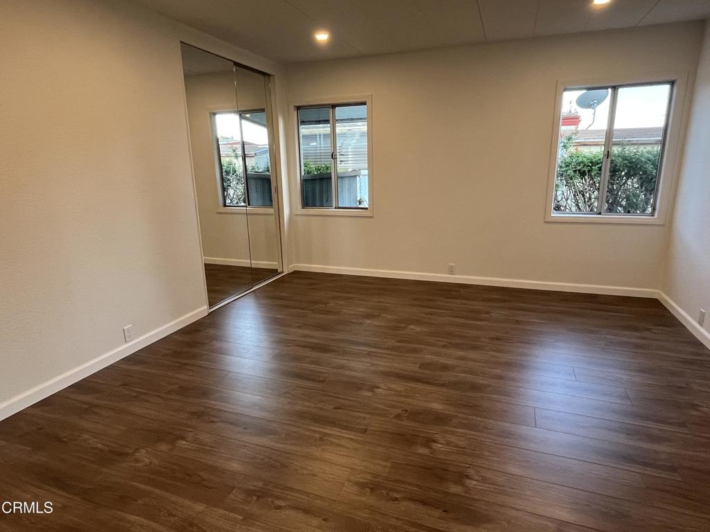 103 Gay Drive, Unit 103 Ventura, CA 93003 - Photo 10 of 17 an empty room with wooden floor and windows