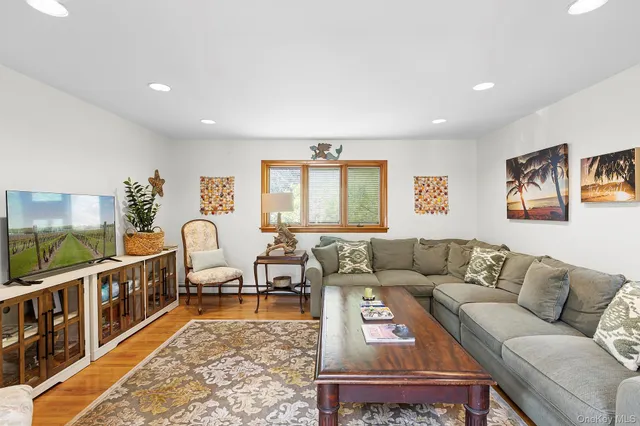 a living room with furniture flat screen tv and a large window