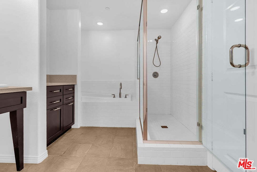 4050 Glencoe Avenue, Unit 405 Marina del Rey, CA 90292 - Photo 29 of 42 a bathroom with a granite countertop sink a shower and mirror