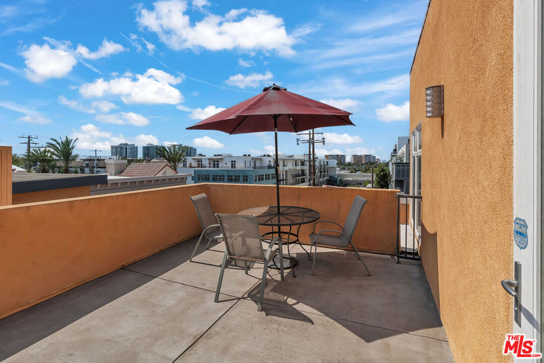 4050 Glencoe Avenue, Unit 405 Marina del Rey, CA 90292 - Photo 34 of 42 a view of a patio with a table and chairs under an umbrella