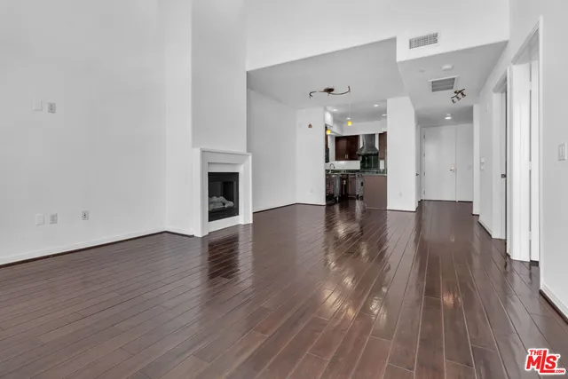 a view of a livingroom with wooden floor and a fireplace