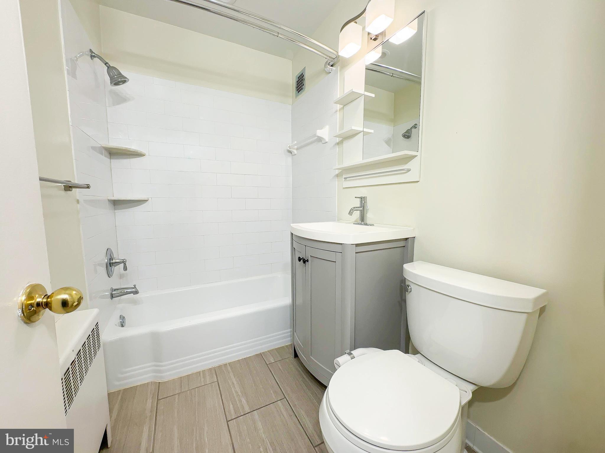 614 Sligo Avenue, Unit 405 Silver Spring, MD 20910 - Photo 21 of 31 a white toilet sitting next to a bathroom sink and tub