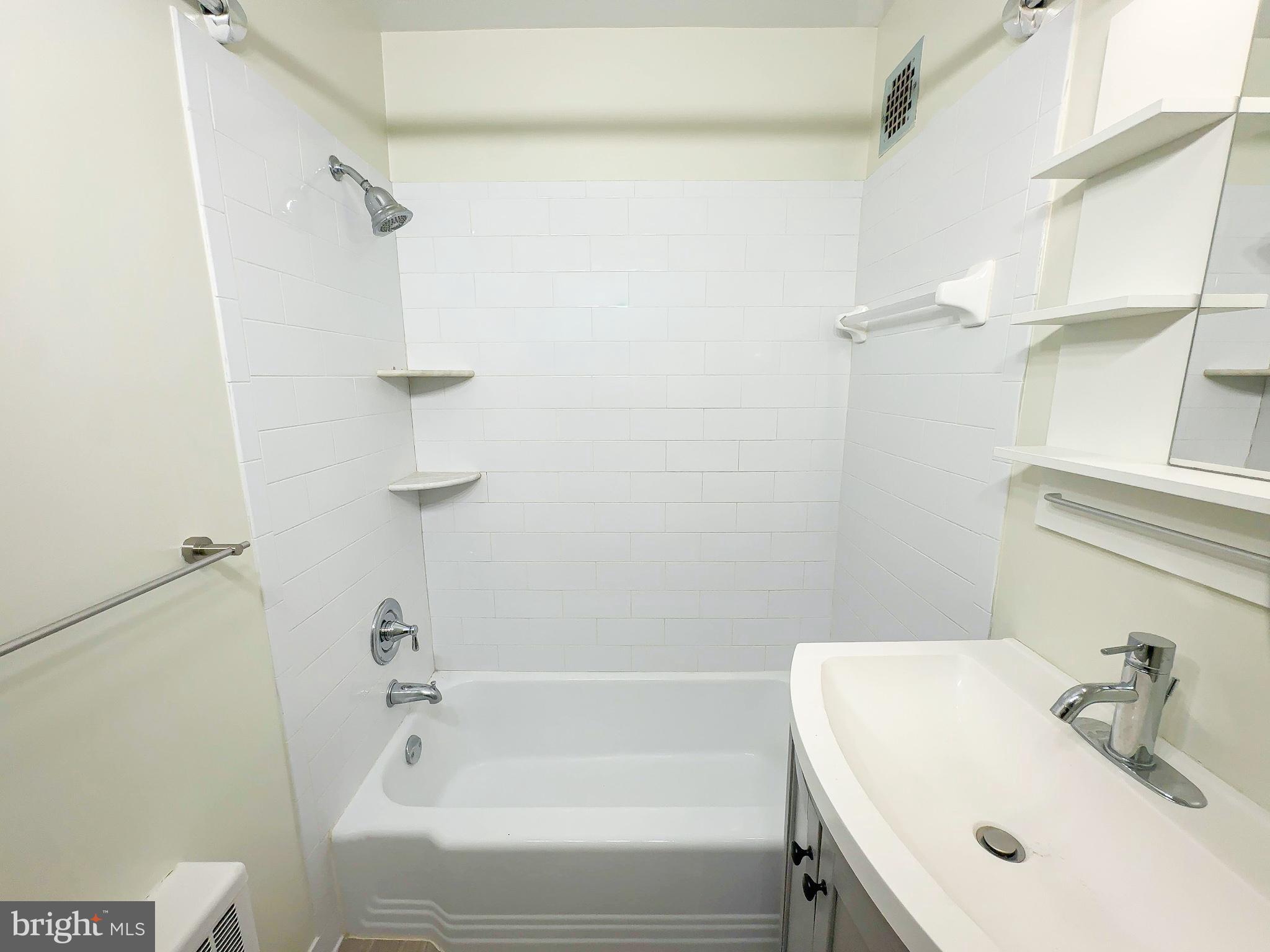 614 Sligo Avenue, Unit 405 Silver Spring, MD 20910 - Photo 22 of 31 a bathroom with a white bath tub