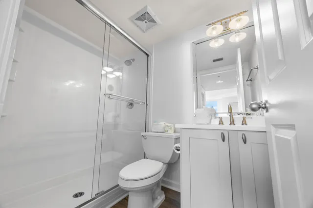 a bathroom with a granite countertop sink toilet a mirror and shower