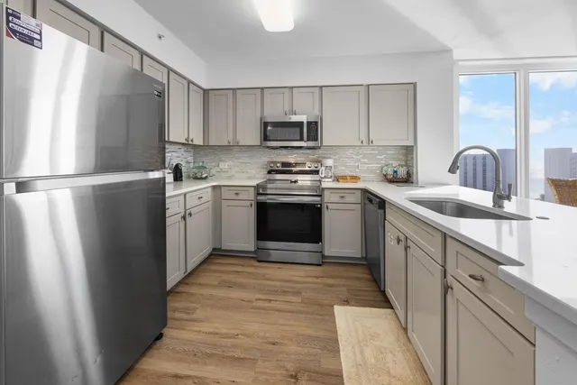 a kitchen with stainless steel appliances granite countertop a refrigerator sink and stove