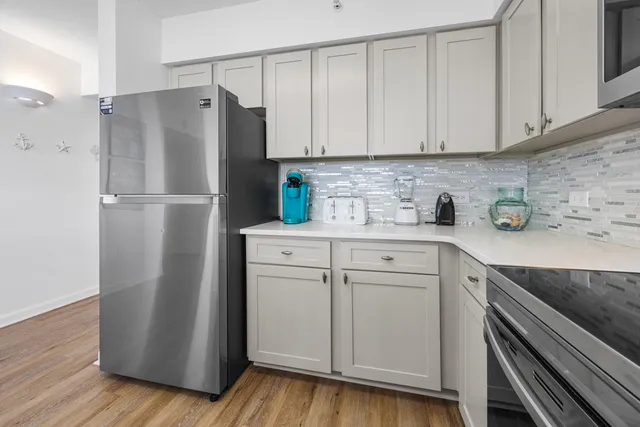 a kitchen with a refrigerator sink and cabinets
