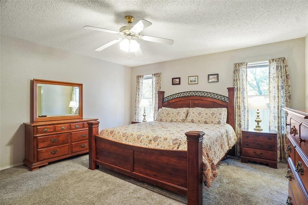1116 Shadow Ridge Drive Azle, TX 76020 - Photo 15 of 27 a bedroom with a bed and a chandelier