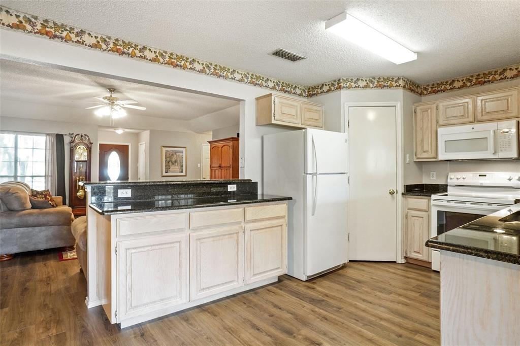 1116 Shadow Ridge Drive Azle, TX 76020 - Photo 10 of 27 a kitchen with stainless steel appliances granite countertop a refrigerator and a stove top oven