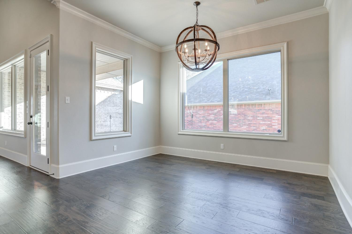 402 Topeka Avenue Lubbock, TX 79416 - Photo 19 of 41 an empty room with wooden floor and windows