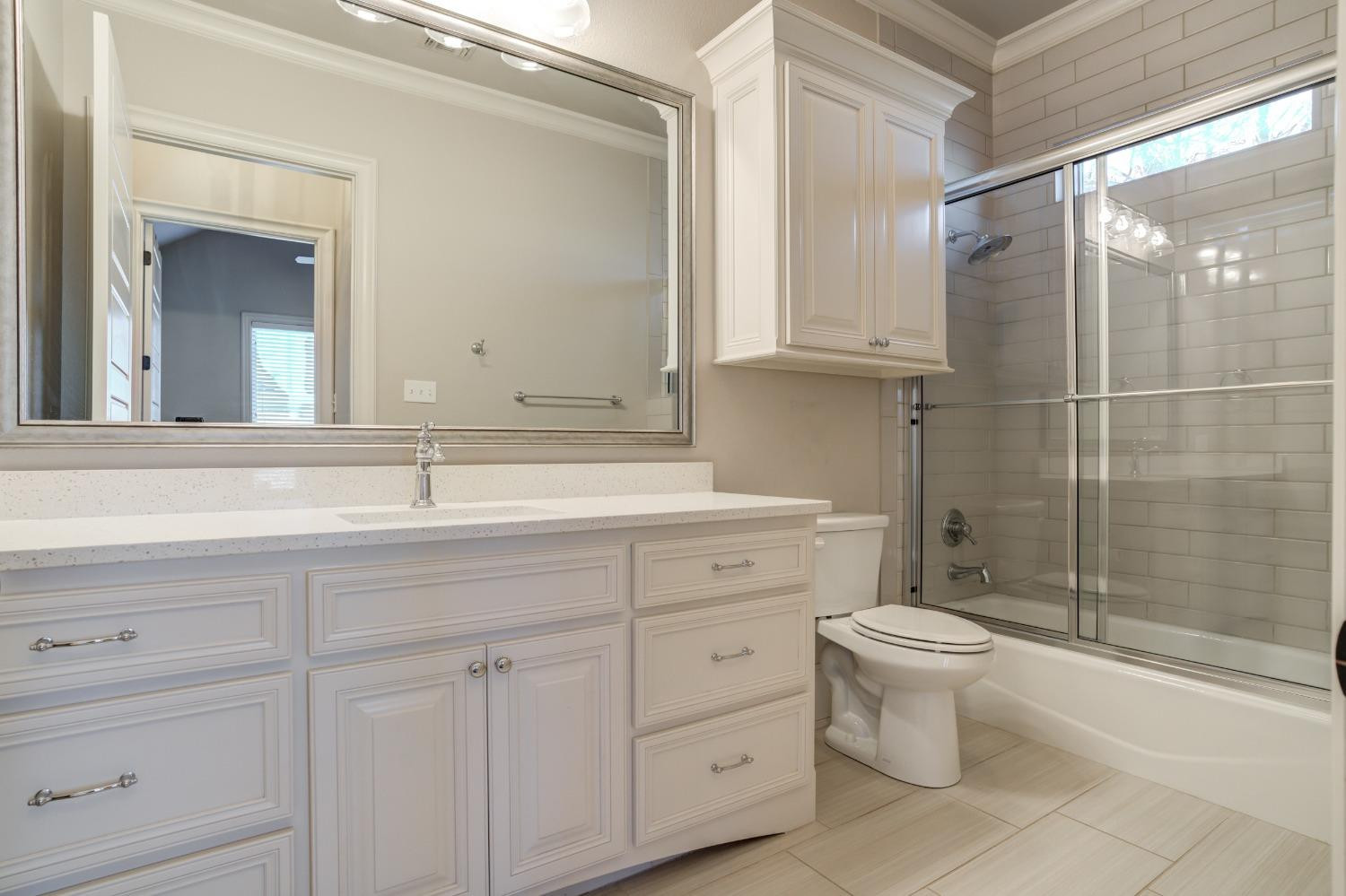 402 Topeka Avenue Lubbock, TX 79416 - Photo 24 of 41 a bathroom with a sink toilet a mirror and shower