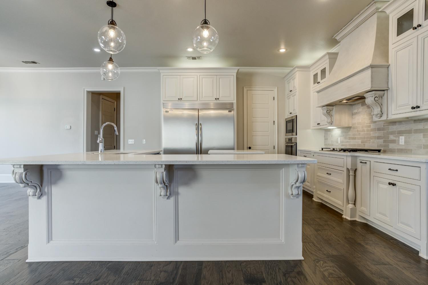 402 Topeka Avenue Lubbock, TX 79416 - Photo 10 of 41 a kitchen with kitchen island white cabinets and stainless steel appliances