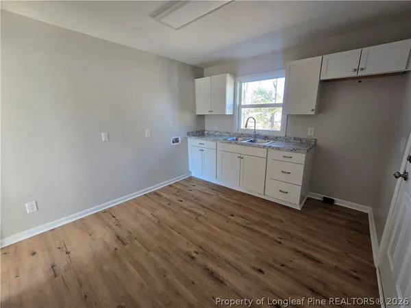 a room with a sink cabinets and window