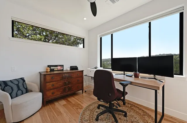 a view of a workspace with furniture and a window