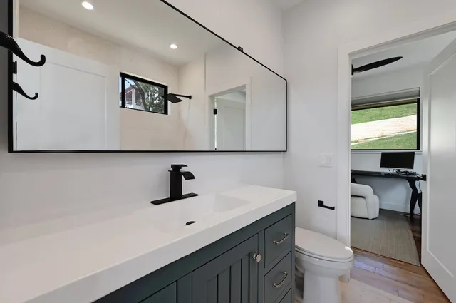 a bathroom with a sink a toilet and mirror