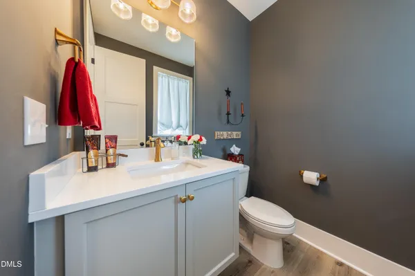 a bathroom with a sink vanity mirror and toilet