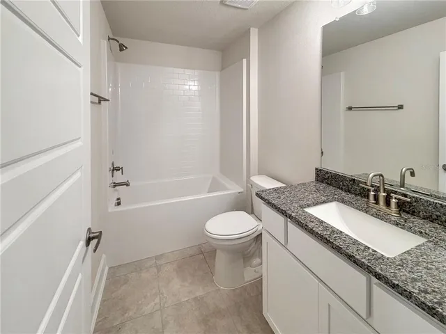 an empty room with windows and ceiling fan