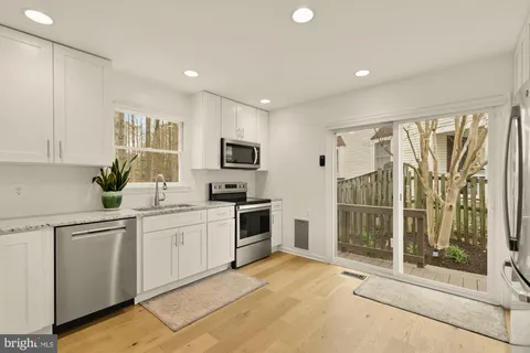a kitchen with white cabinets and white appliances