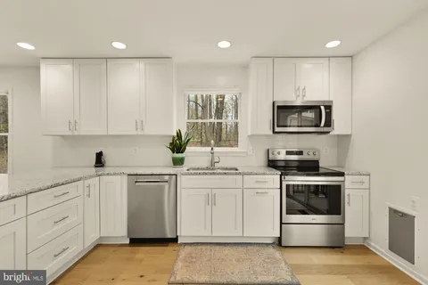 a kitchen with a sink stove and microwave