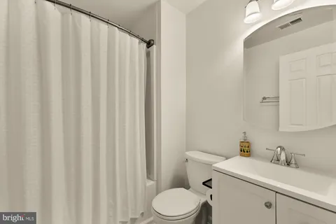 a bathroom with a sink a toilet and shower curtain