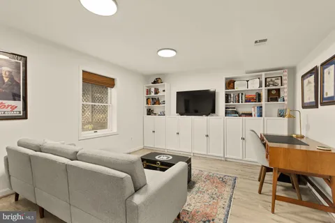 a living room with furniture a rug and white walls