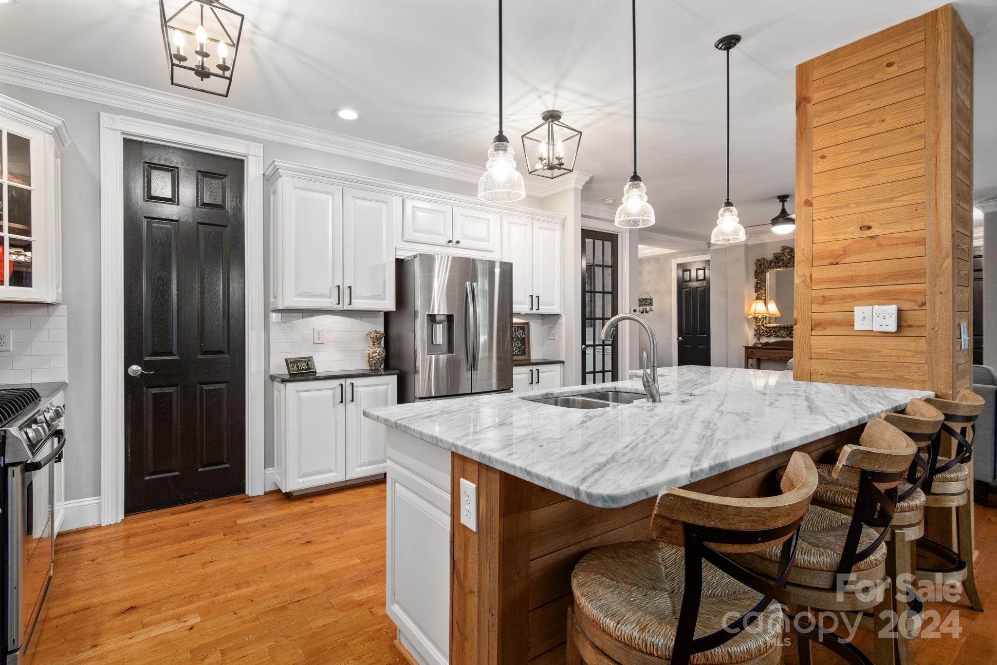2049 Rocky Stream Road York, SC 29745 - Photo 8 of 47 a kitchen with stainless steel appliances kitchen island granite countertop a dining table chairs and refrigerator