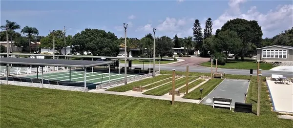 a view of a swimming pool with a bench and trees