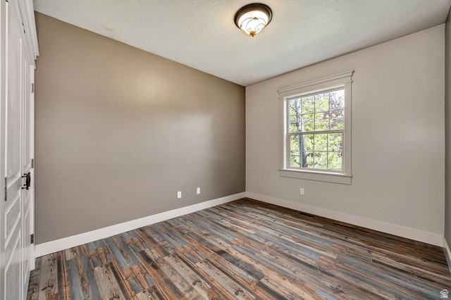 288 525 South Providence, UT 84332 - Photo 22 of 71 Room featuring wood-finish flooring, a single window with detailed trim, and a semi-flush mount ceiling light