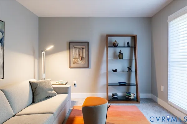 a living room with furniture a rug and a window