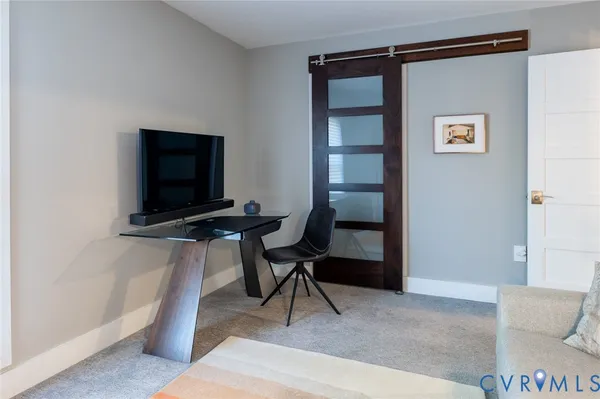 a view of a workspace with furniture and a window