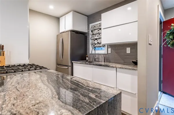 a kitchen with stainless steel appliances granite countertop a sink stove and refrigerator