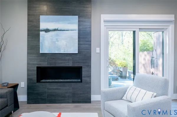 a living room with furniture a large window and a fireplace