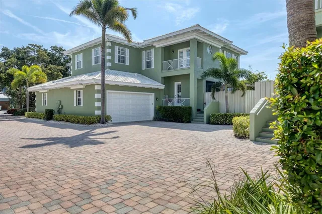 a front view of a house with a yard and potted plants