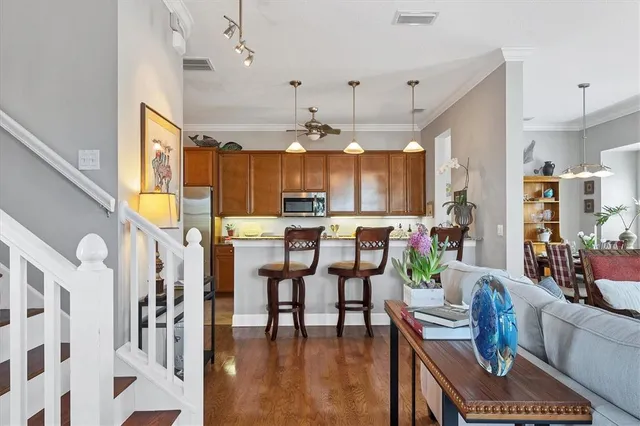 a kitchen with stainless steel appliances granite countertop a refrigerator a stove and a sink with wooden floor