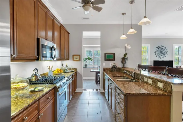 a dining room with furniture a potted plant and a large window
