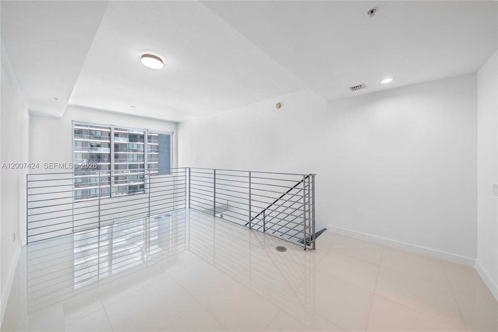 60 Southwest 13th Street, Unit 2420 Miami, FL 33130 - Photo 17 of 30 a view of a livingroom with a white wall and a window