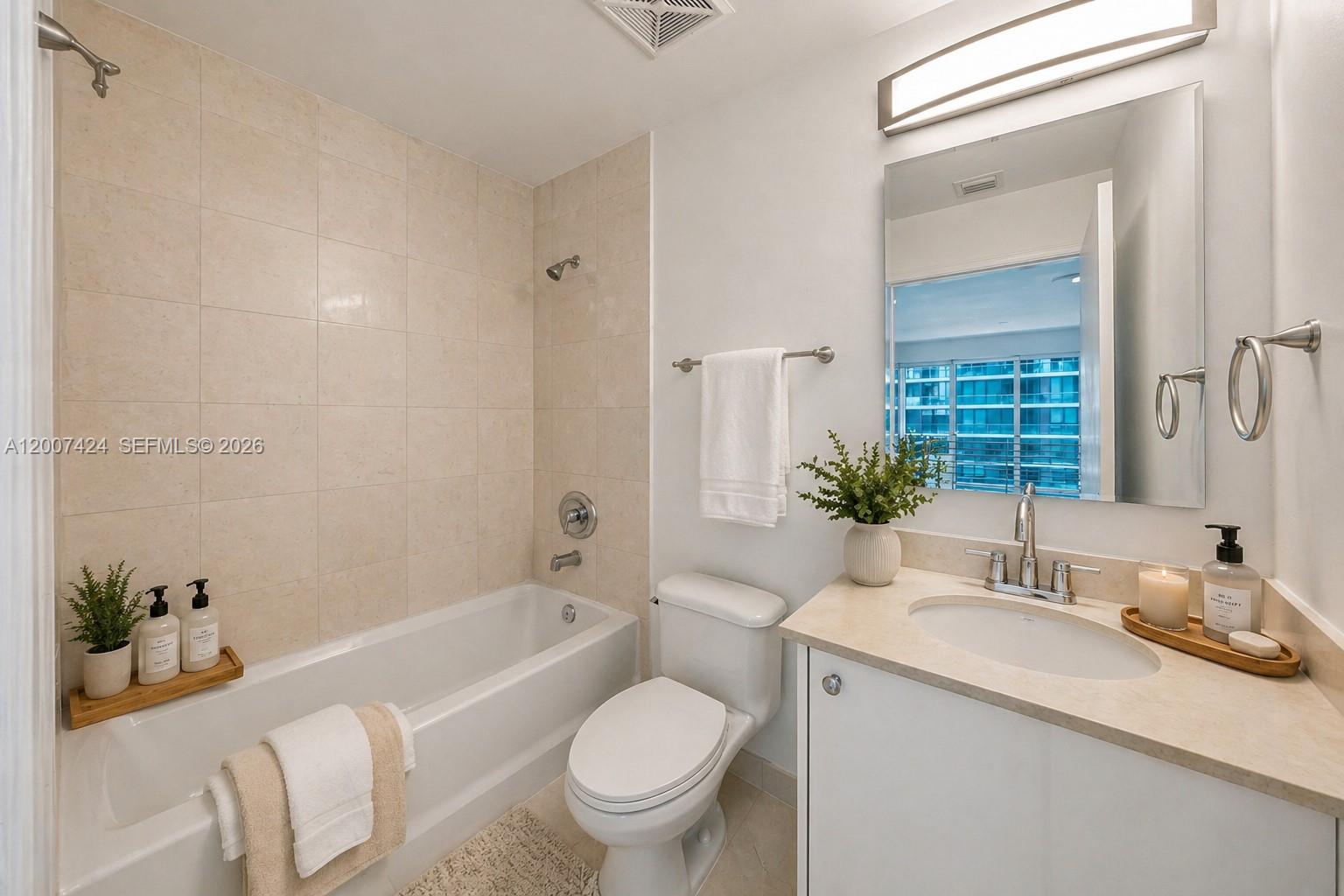 60 Southwest 13th Street, Unit 2420 Miami, FL 33130 - Photo 24 of 30 a bathroom with a granite countertop toilet a sink and a bathtub