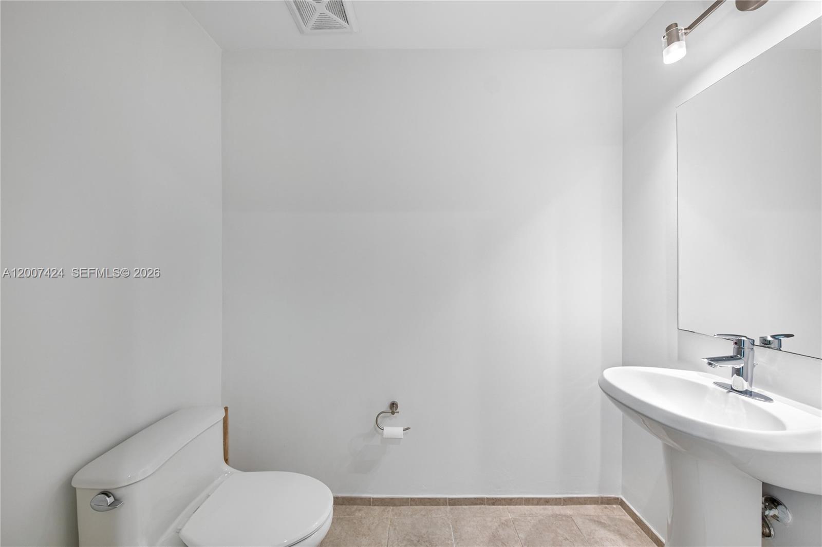60 Southwest 13th Street, Unit 2420 Miami, FL 33130 - Photo 25 of 30 a bathroom with a toilet sink and mirror