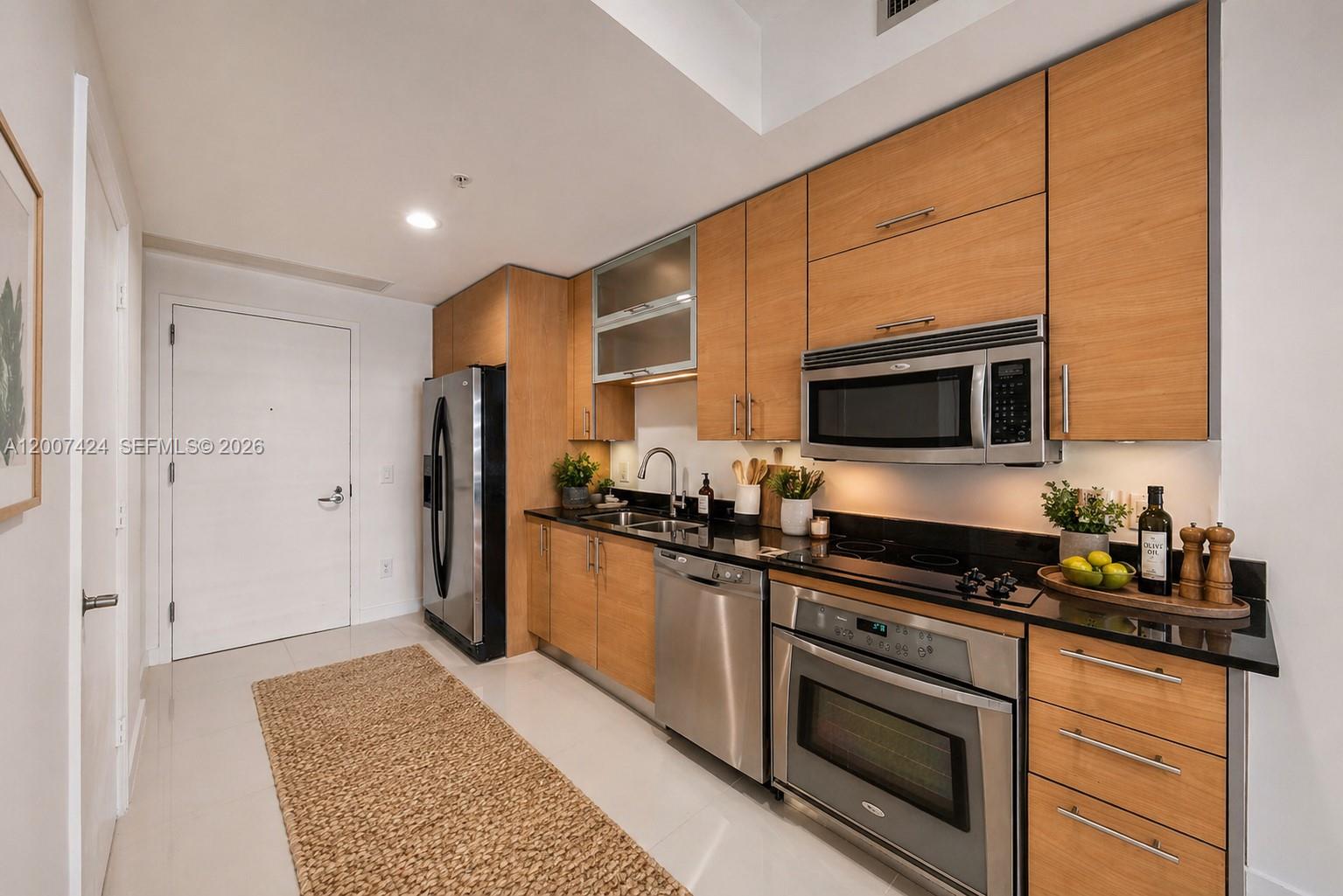 60 Southwest 13th Street, Unit 2420 Miami, FL 33130 - Photo 10 of 30 a kitchen with stainless steel appliances granite countertop a refrigerator and a stove top oven