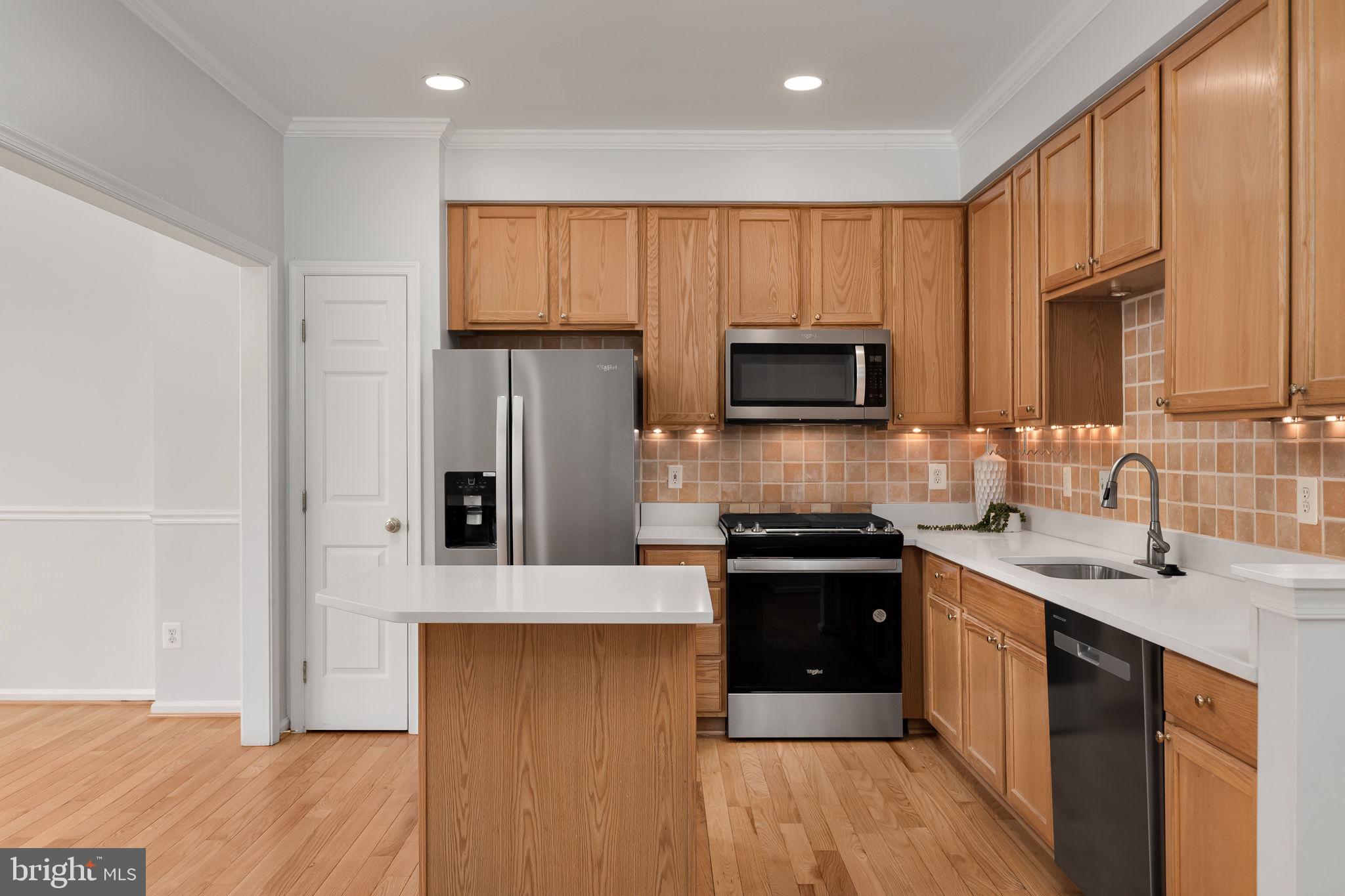 43002 Center Street Chantilly, VA 20152 - Photo 7 of 35 a kitchen with stainless steel appliances granite countertop a stove a sink dishwasher a refrigerator and a microwave oven with wooden floor