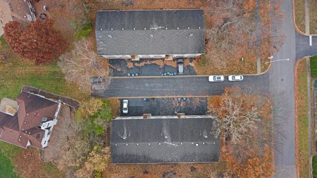 an aerial view of a house with a yard and a large tree