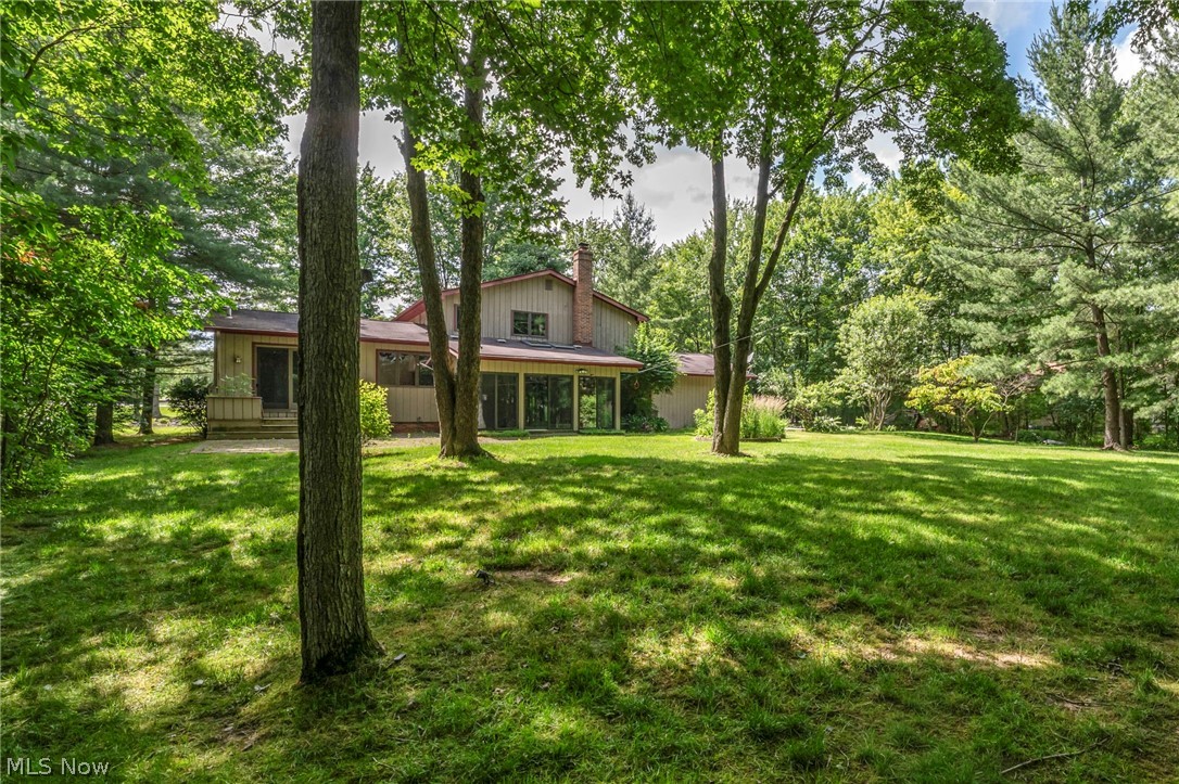 6845 Liberty Road Solon, OH 44139 - Photo 46 of 47 Expansive rear yard with a manicured lawn, mature trees, and a two-story residence with a covered patio