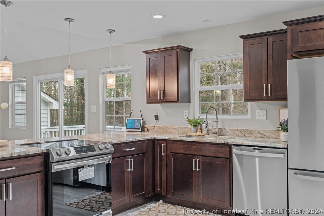 7039 Pine Road Sanford, NC 27332 - Photo 13 of 35 a kitchen with stainless steel appliances granite countertop a sink stove and refrigerator