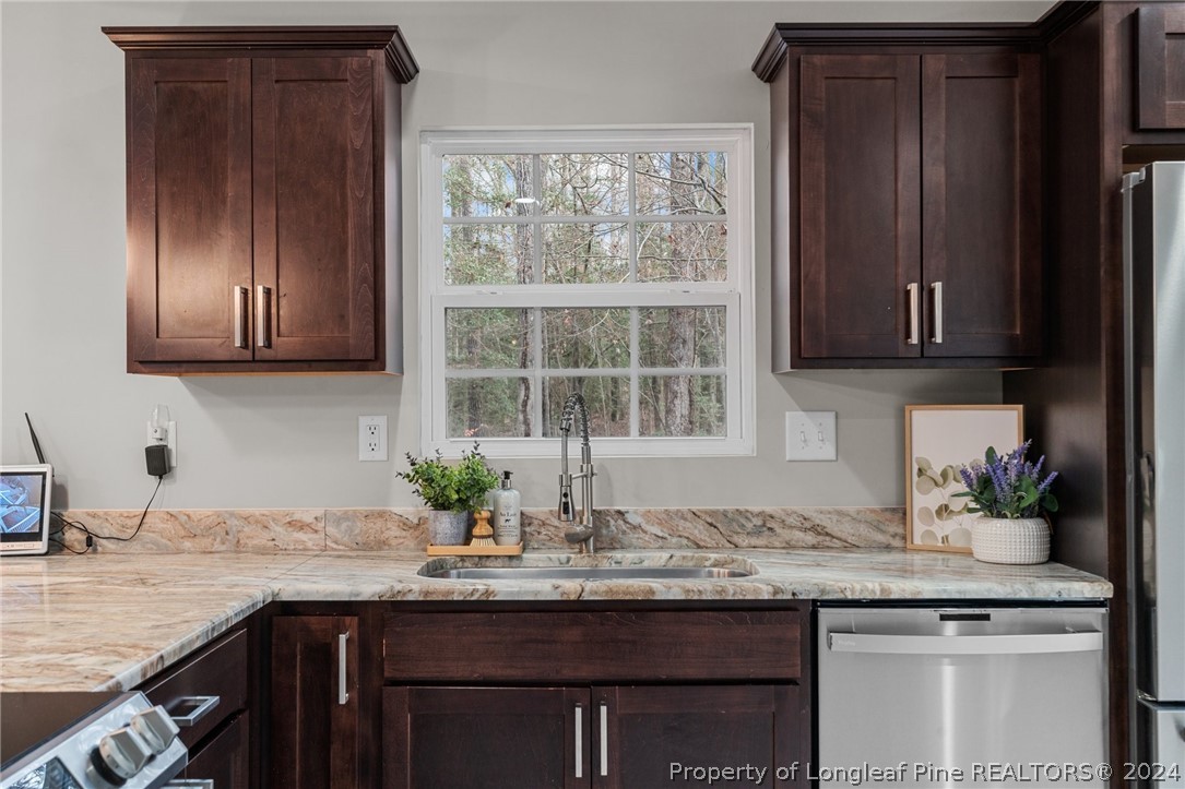 7039 Pine Road Sanford, NC 27332 - Photo 15 of 35 a kitchen with granite countertop stainless steel appliances sink and cabinets